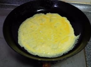 平底锅上火，放上适量食用油，把蛋液倒进平底锅里，转动平底锅，摊成一张鸡蛋皮；