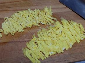 先后摊两张鸡蛋皮出来，对折，切成细条；