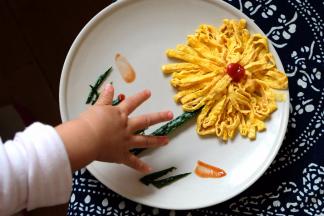 来看一下我家二宝的小魔爪，我拍照片的时候人家就伸出手了，看来小朋友都喜欢漂亮的事物啊，看到这朵漂亮的花儿就想伸手去抓了。赶紧拍了两张，就让小妞自己抓着吃了，我就去个厨房转个圈的空儿，人家就已经吃了大半朵花了，平时对炒鸡蛋煎鸡蛋一概不感兴趣的小妞，居然把这朵花吃光了！