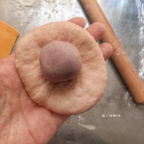松驰好的面团包入馅料，我这里包入了10克的芋头馅，可以换成自己喜欢的馅料，肉松或者其它，或者不放也可以，直接做成小餐包