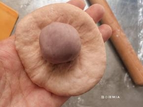 松驰好的面团包入馅料，我这里包入了10克的芋头馅，可以换成自己喜欢的馅料，肉松或者其它，或者不放也可以，直接做成小餐包