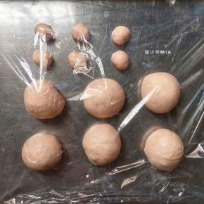 然后再分出6份5克的小面团，剩余的面团再平均分为6份大面团，揉圆盖保鲜膜松弛15分钟