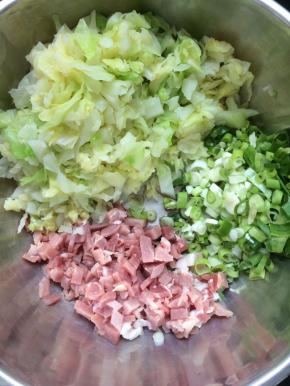将圆白菜攥干水份，放入盆中，加入猪肉丁，葱