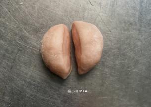 5克的小面团揉圆，用刀一分为二，粘在面团顶端两边，做成耳朵的样子
