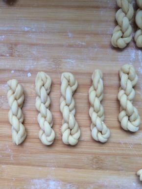 左手捏住一端，右手朝一个方向搓劲，对折，提起来，麻花就自己卷好了