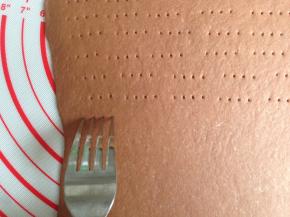 用叉子在面皮上面叉出有规则排列的小孔