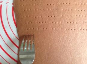 用叉子在面皮上面叉出有规则排列的小孔