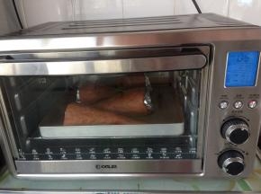 发酵好的面包坯和那碗热水一并取出。将烤箱预热到165度，烘烤17分钟。烘烤好的面包取出，将面包筒内的锡纸取出