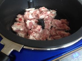 搅拌锅装适量的清水，将排骨、一块姜片和几滴黄酒放进锅里。点击一下开关电源，炒菜锅自动加热3分钟。预热完毕后，选择“蒸炖”，时间5分钟。