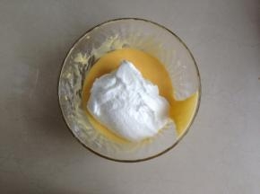 将三分之一打发好的蛋白加入到蛋黄糊里，切拌均匀。再倒回到蛋白盆里切拌均匀，不可划圈搅拌会消泡的