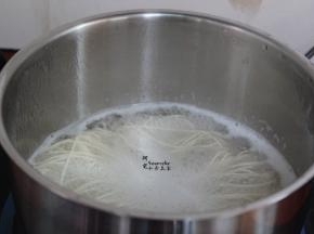 清水煮沸，放入面条煮软，捞出，放油拌均；