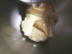 厨师机开至揉面档程序，揉至面团表面光滑，大致出膜加入盐和黄油
