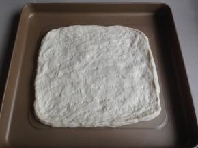 排气后，松驰15分钟，再擀平，放在烤箱自带的不粘烤盘上，松驰15分，用叉子叉出小孔