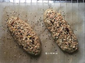 撒上燕麦片、白芝麻、黑芝麻，放在温暖处进行最后发酵