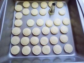 依次摆放再烤盘中，(我的是不粘烤盘，如果不是这种记得再烤盘上垫油纸。) 
再取一个小一号的曲奇裱花嘴，再按好的大圆形里按出一个小圆形，依次做完。