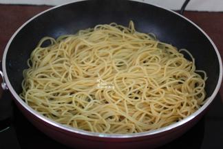 锅中少许油，放入拌过橄榄油的意面，把调均的鸡蛋淋在意面上面