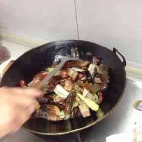 然后下入小龙虾爆炒，这时候的油温一定要高，注意翻炒均匀，至所有的虾尾都卷起