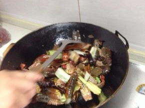 然后下入小龙虾爆炒，这时候的油温一定要高，注意翻炒均匀，至所有的虾尾都卷起