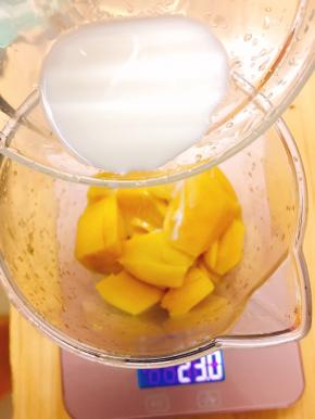芒果去皮切成小块放入搅拌机中，加入15克牛奶