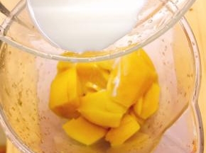 芒果去皮切成小块放入搅拌机中，加入15克牛奶