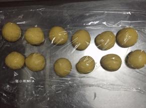 将发酵好的黄色面团排气，先取出48克面团（用来做维尼熊的耳朵和手），剩余的面团平均分为12份，揉圆并用保鲜膜盖好，醒发10分钟