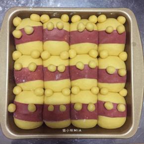 将1克的小面团揉圆，沾点水，如图安放，做成维尼熊的耳朵和手，发酵至两倍大