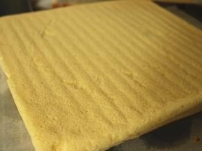 晾凉的蛋糕片揭去油纸，根据盒子大小裁成合适的形状。