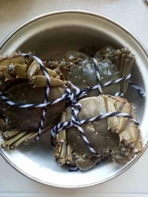 把螃蟹用水冲洗，再用牙刷刷洗干净，为了成品漂亮美观，我用绳子扎紧，这样蒸出来的螃蟹脚不容易掉，为了省事，也可以不用