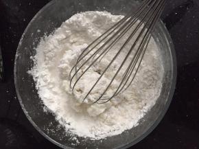 将水晶粉倒入盆中，分次加入260克菊花茶，搅拌均匀。