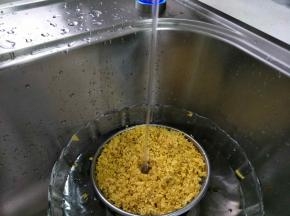 用漏网勺辅助摁压花，在干净的水中冲洗一次，洗掉灰尘和一些杂质。