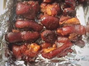 焖至汤汁浓稠，将猪蹄夹放在烤盘上，洒上适量烧烤粉，烤箱200度预热