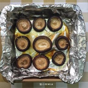 此时香菇也已烘烤好了，拿出来放入馅料锅中滚一圈，然后再夹起来重新放回烤盘