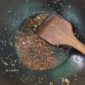 趁着烘烤香菇的时间，来准备馅料的部分，冷锅下油，下蒜蓉和指天椒，小火爆香后加入适量生抽和糖，临关火在撒点孜然粉和芝麻油，关火备用