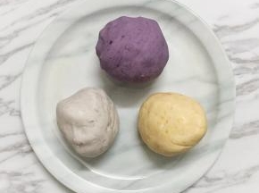 先做芋头味的，先用90克木薯粉加40克开水，用筷子搅匀，然后加25克糖和另外90克的木薯粉以及蒸熟的芋头，如果面团状态较干，可适量加点清水调整下，最终揉成一个光滑的面团