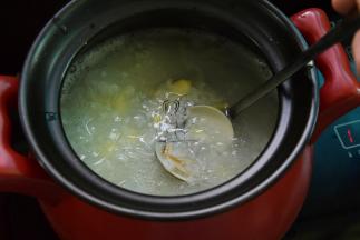 将浸泡的海蚌洗刷干净，和姜丝一起加入粥中煮开壳