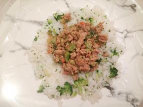 拿一个平盘铺上保鲜膜，再铺上一层米饭，中间放上馅料