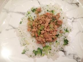 拿一个平盘铺上保鲜膜，再铺上一层米饭，中间放上馅料