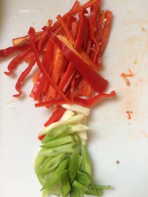 将红椒切长条，葱切斜段。
