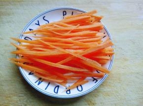 胡萝卜去皮洗干净，切片，再切丝。(如果喜欢吃辣的，可以把胡萝卜换成红辣椒)