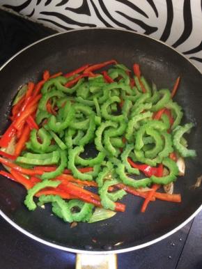 加入焯过水的苦瓜，放入盐，翻炒均匀，炒几分钟，最后加入鸡精炒匀关火。