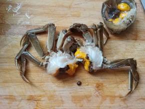 拿下蟹盖后，摘掉蟹心蟹胃，把蟹从中间分开。