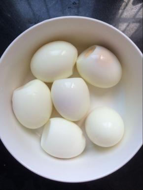 在准备一个锅，放入鸡蛋煮熟，将煮熟的鸡蛋捞出放入凉水中过凉，剥去鸡蛋皮备用