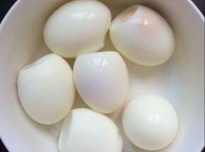 在准备一个锅，放入鸡蛋煮熟，将煮熟的鸡蛋捞出放入凉水中过凉，剥去鸡蛋皮备用