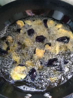 锅中放入油烧至8成热时，放入茄子，炸熟