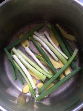 准备一个汤锅，将姜片，葱段铺在底层