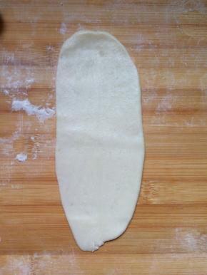 把包好的面团收口朝上擀成牛舌状