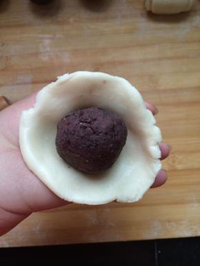 擀成一个大点的皮，将豆沙团包紧
