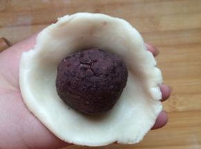 擀成一个大点的皮，将豆沙团包紧