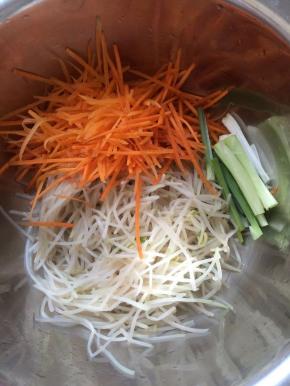 沥干水份，放入盆中，放入葱，胡萝卜