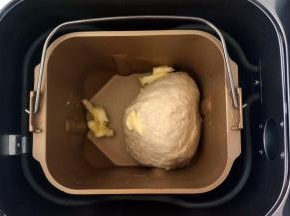 揉成光滑的面团后，加入软化的黄油，再次启动揉面程序。